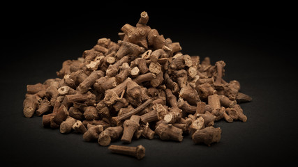 Pile of Organic Ganthoda or Long pepper Roots (Piper longum) on dark background.