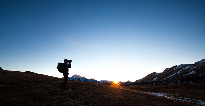 Photographer in the mountains at sunset
