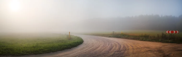 Poster Gravel road in the fog. Turn of gravel road. Rural landscape. Panoramic shot. Toned image. © Veresovich