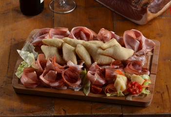 Cortes de jamones crudos n una tabla de madera.