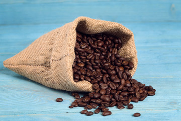 Bag of roasted coffe beans on a blue background