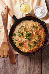 Potato pancakes with herbs in a frying pan. vertical top view
