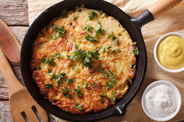 Potato pancakes with herbs close-up in a frying pan. Horizontal top view
