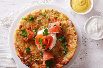 Potato pancakes with salmon and sauce close-up. Horizontal top view
