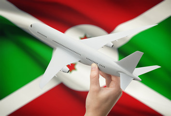 Airplane in hand with flag on background - Burundi