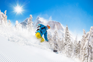 Skier skiing downhill in high mountains