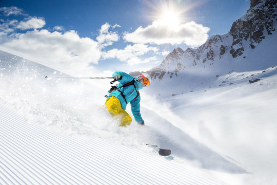 Skier skiing downhill in high mountains