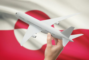 Airplane in hand with flag on background - Greenland