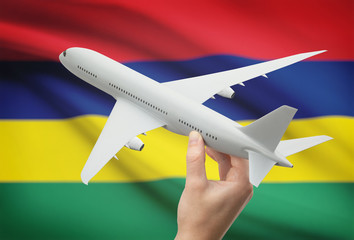 Airplane in hand with flag on background - Mauritius