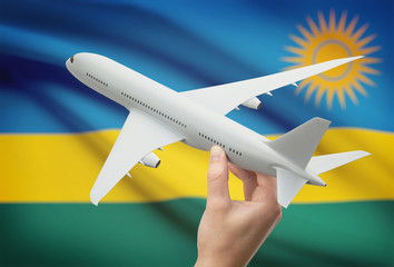 Airplane in hand with flag on background - Rwanda