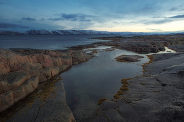 Fototapeta na wymiar Granite Beach and across the bay. Barencevo sea. Kola Peninsula. Murmansk region. Russia.