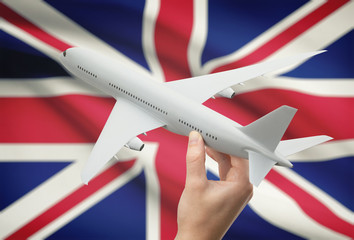 Airplane in hand with flag on background - United Kingdom