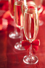 Glasses of champagne on red background