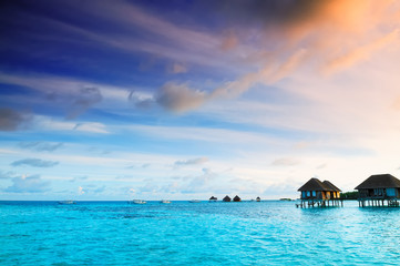 Sunrise over water bungalows in Maldives