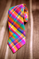 Multi colored exclusive silk tie on wooden surface