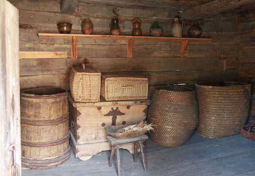 Chests, barrels and a shelf with dishes in the ancient peasant h