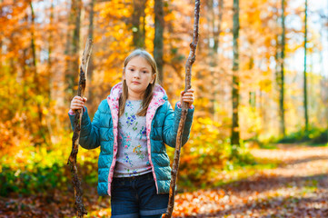 Outdoor portrait of a cute little girl in autumn forest