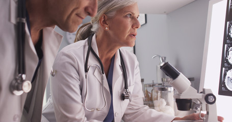 Two mature white neurologists studying x-rays