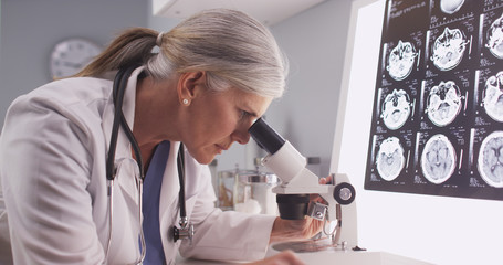 Mature white neurologist female looking at x-rays