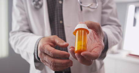 Senior doctor holding prescription bottle 