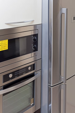 Closeup built-in microwave oven, oven and fridge