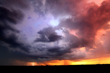 Fototapeta na wymiar Lightning and thunderstorm clouds at sunset in Indiana