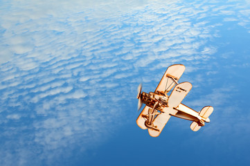 Wooden toy airplane in the blue sky © Stepan Bormotov