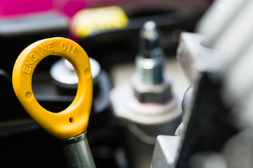 Close-up of yellow oil level dipstick on a car engine. Illustrating service, Technology, workshop, Repairing.
