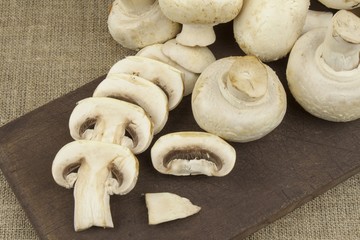 Raw mushrooms on a cutting board. Preparation of Champignons in the kitchen. 
