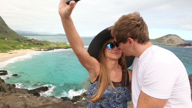 Couple tourists taking self portrait with camera phone on Hawaii, Oahu, Makapuu