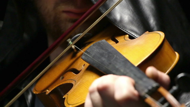 Man in hood playing the fiddler