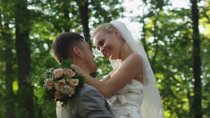 Just married couple hug each other in a sunny park