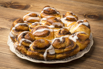 Homemade yeast cake with cinnamon on the brown wooden background.