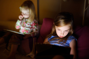 Two little sisters using digital tablet computer
