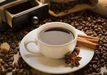 cup of coffee with cinnamon and coffee beans star anise