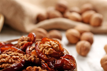 Walnut and date fruit on wooden table, close-up