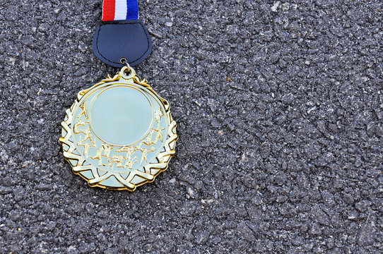 gold medal on asphalt road with copy space area
