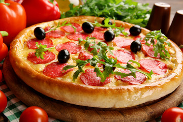 Tasty pizza with salami on decorated wooden table, close up