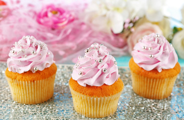 Tasty cupcakes on plate, on color wooden background