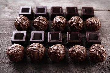Delicious chocolate candies on wooden background