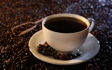 Cup of hot coffee on coffee beans background