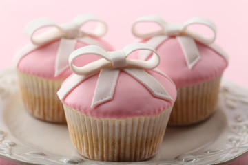 Tasty cupcakes with bow on color wooden background