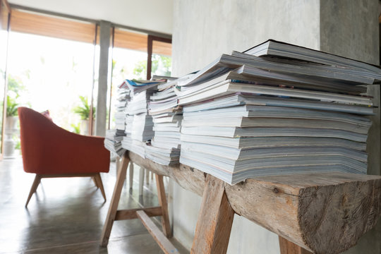 stack of magazine book on wooden table shelf in living room