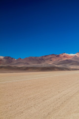 Fototapeta na wymiar Dust road in Salvador Dali Desert in Eduardo Avaroa Andean Fauna National Reserve, Bolivia