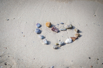 Stones arranged in a heart shape on the sand