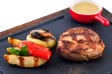 Grilled beef steak on wooden pan.