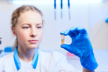 Woman scientist keeped in hand a test tube with analyzes in the modern laboratory