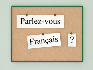 Cork board and sheets paper with the text in French (Do you spea