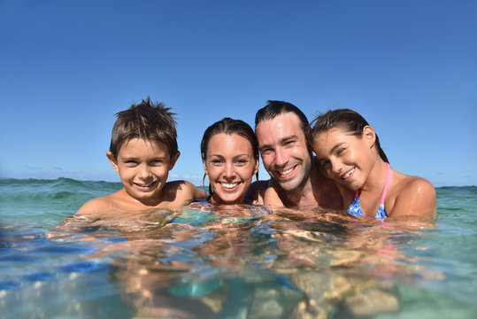 Happy Family Enjoying Swimming In Caribbean Sea