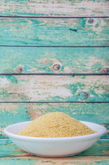 Dried bakers yeast in white bowl over wooden background